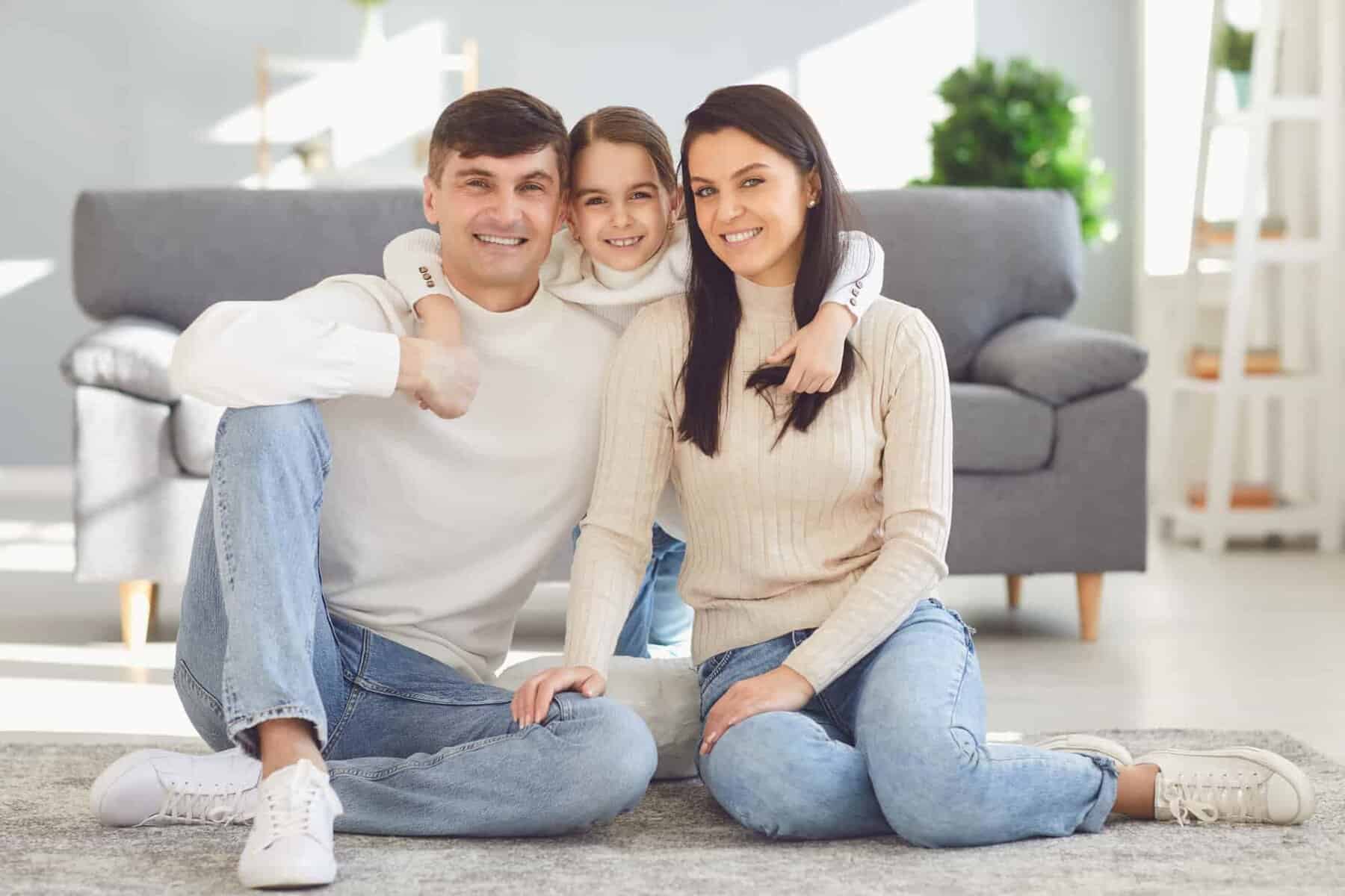 A family of three smiles