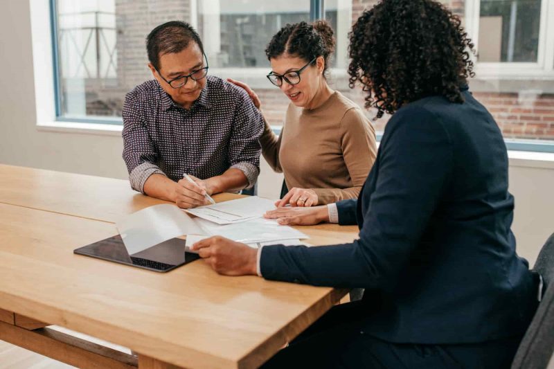 A man and two women review documents together