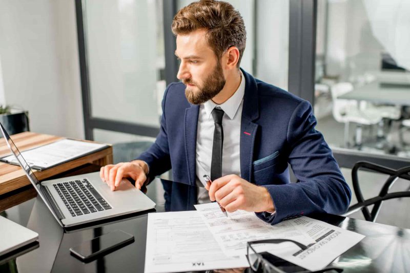 A man in a suit works on a computer