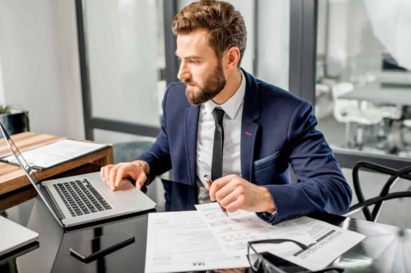 A man in a suit works on a computer